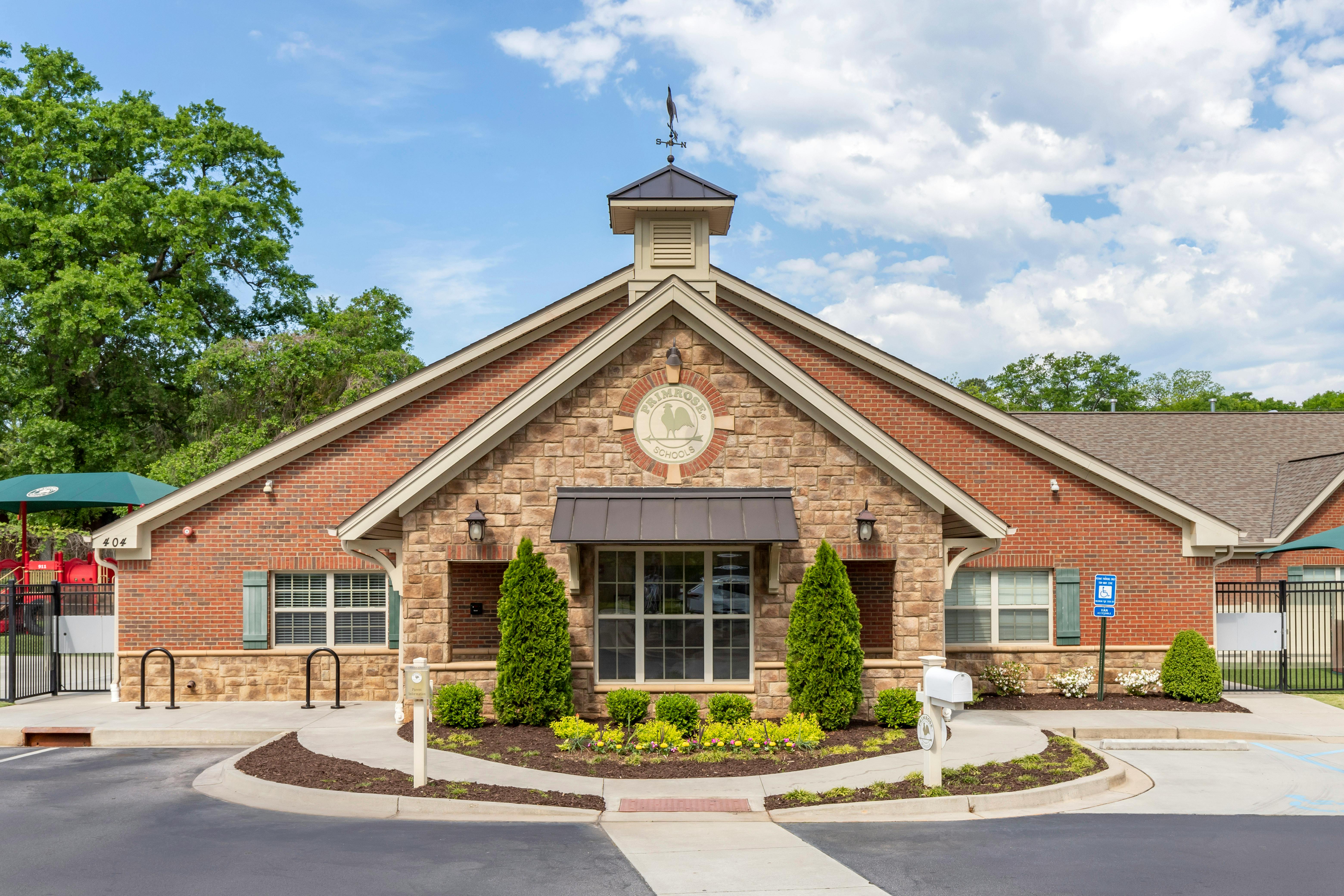 Front exterior of a Primrose Schools building, red brick with stone facade