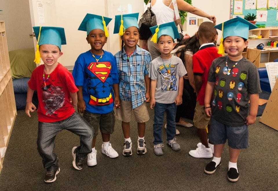 Group of children wearing graduation caps