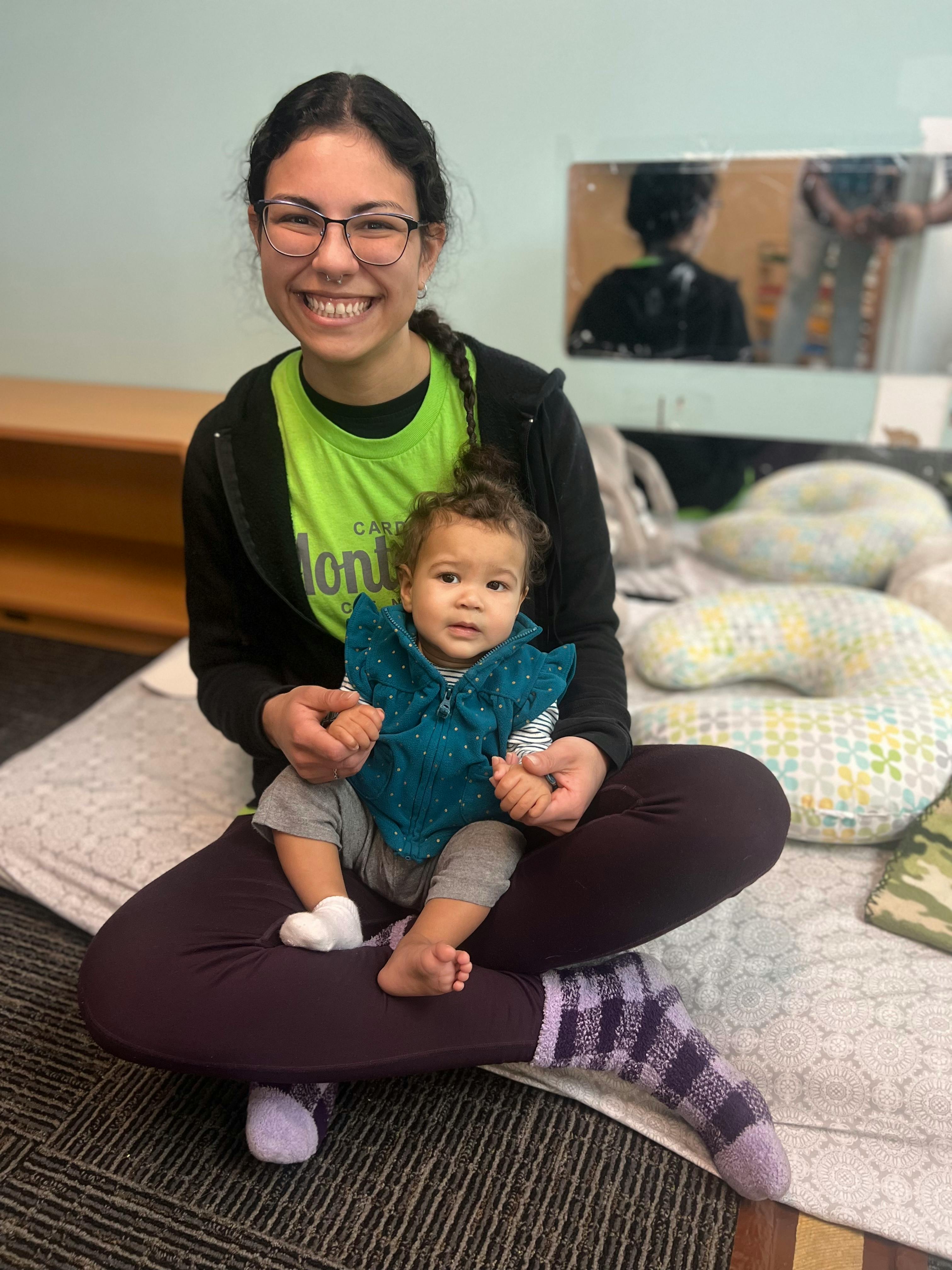 Person sitting on floor holding a child