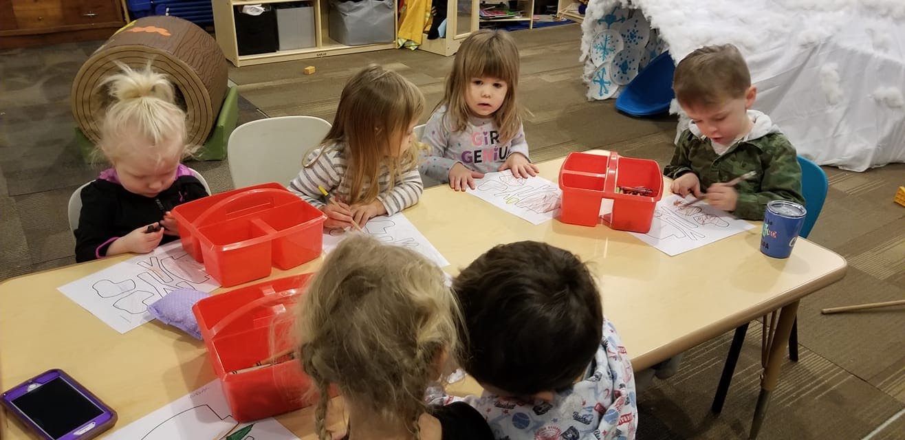 Children sitting at a table drawing