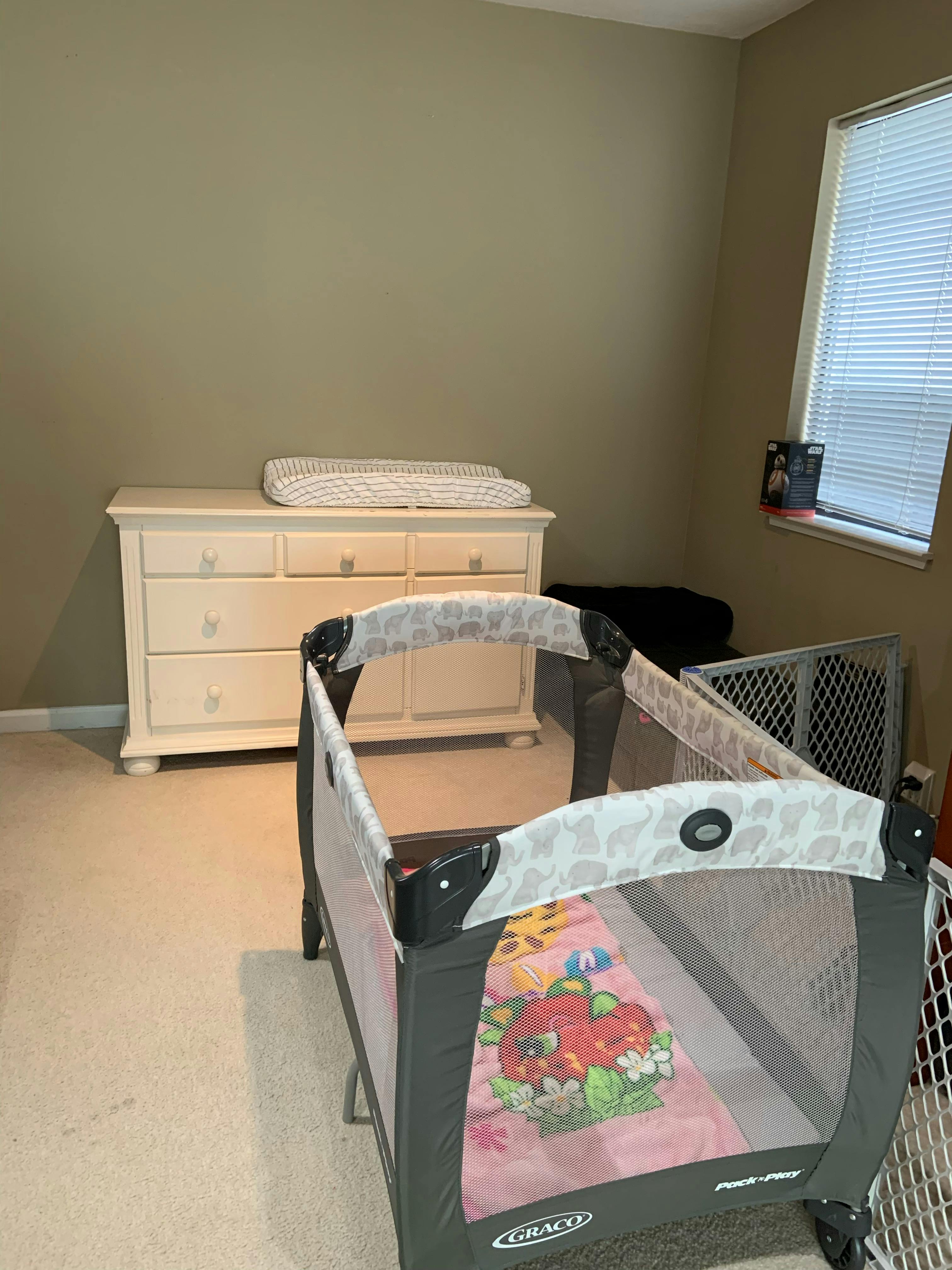 Playard with a changing table and dresser in a room