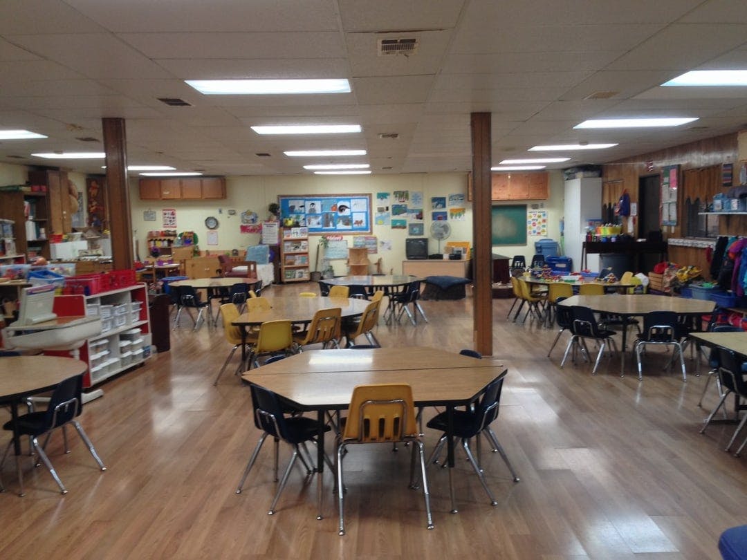 Empty classroom with small tables and chairs