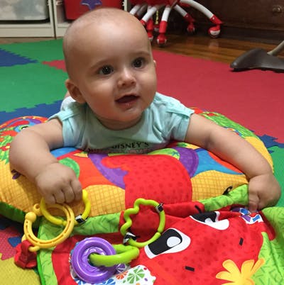 Child on a colorful playmat with toys