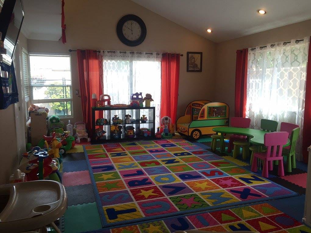 Playroom with colorful alphabet rug, toys, and small table with chairs