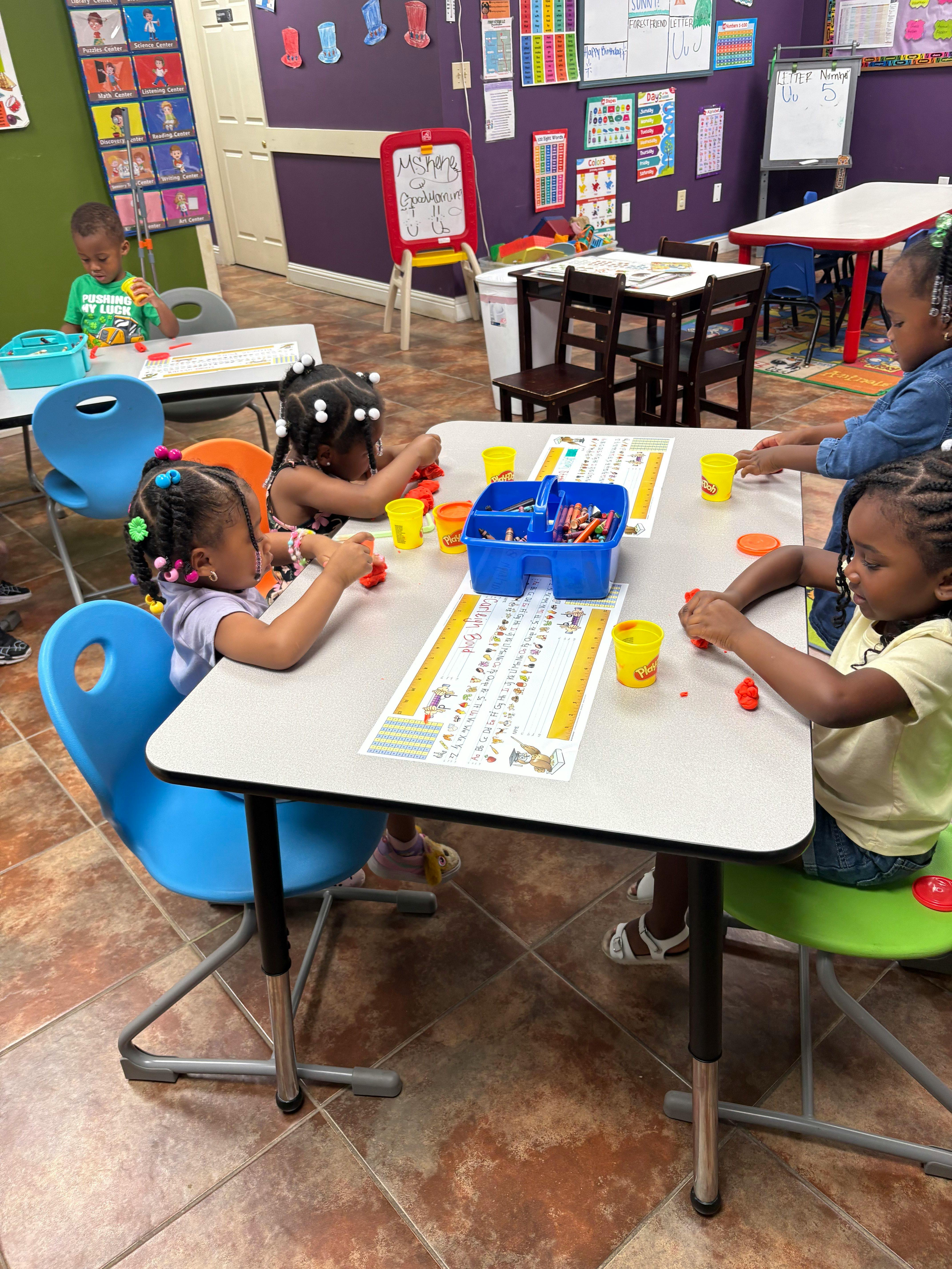 Children playing with playdough at tables in a classroom