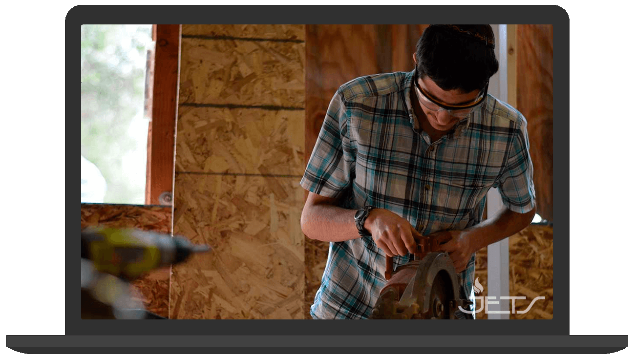 Person wearing safety glasses using a circular saw