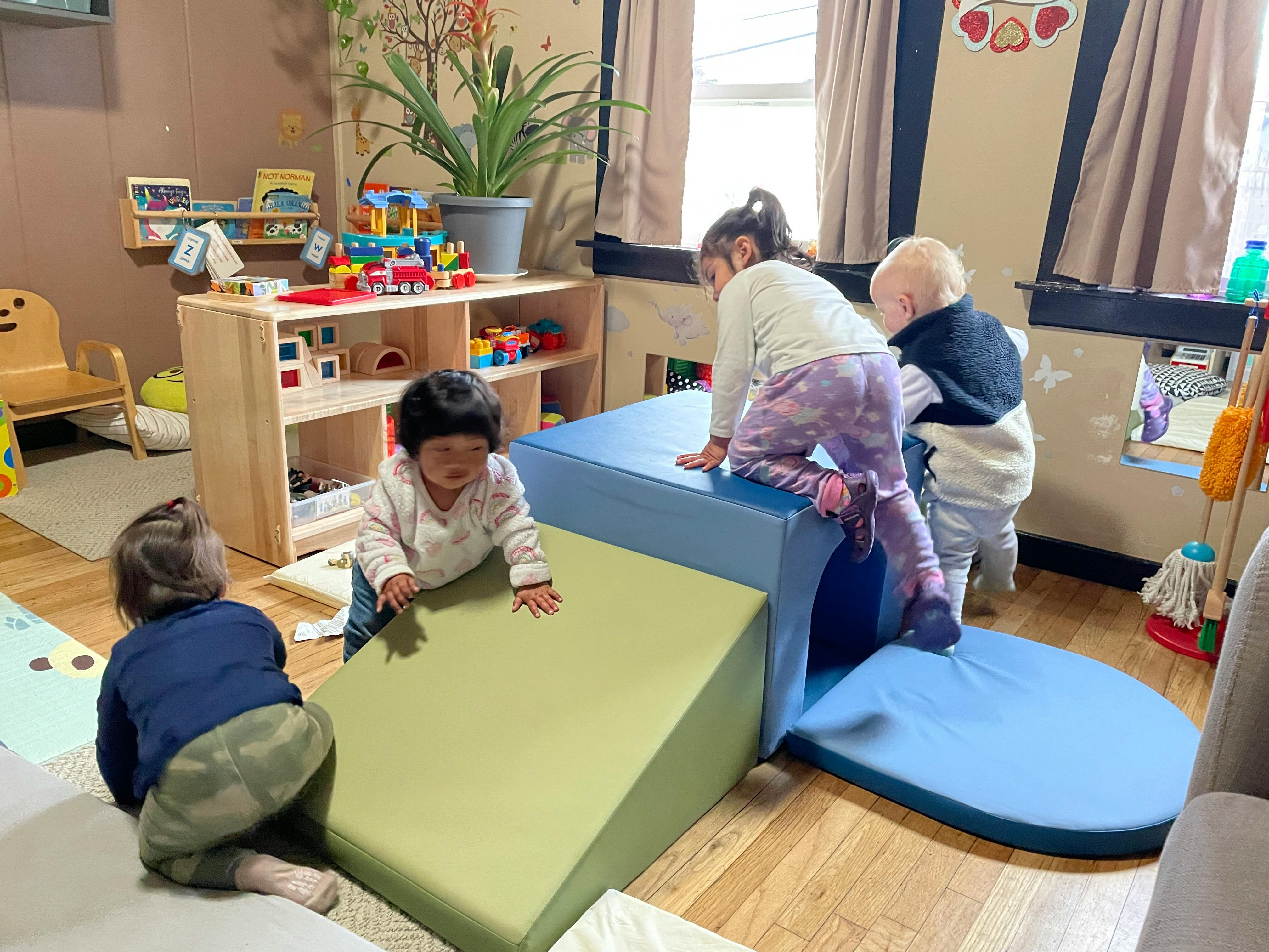Children playing on soft play equipment in a room