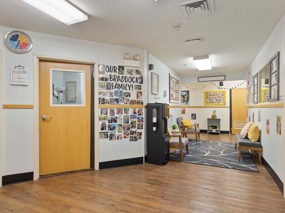 Lobby with a collage of photos on the wall, seating area, and wooden floor