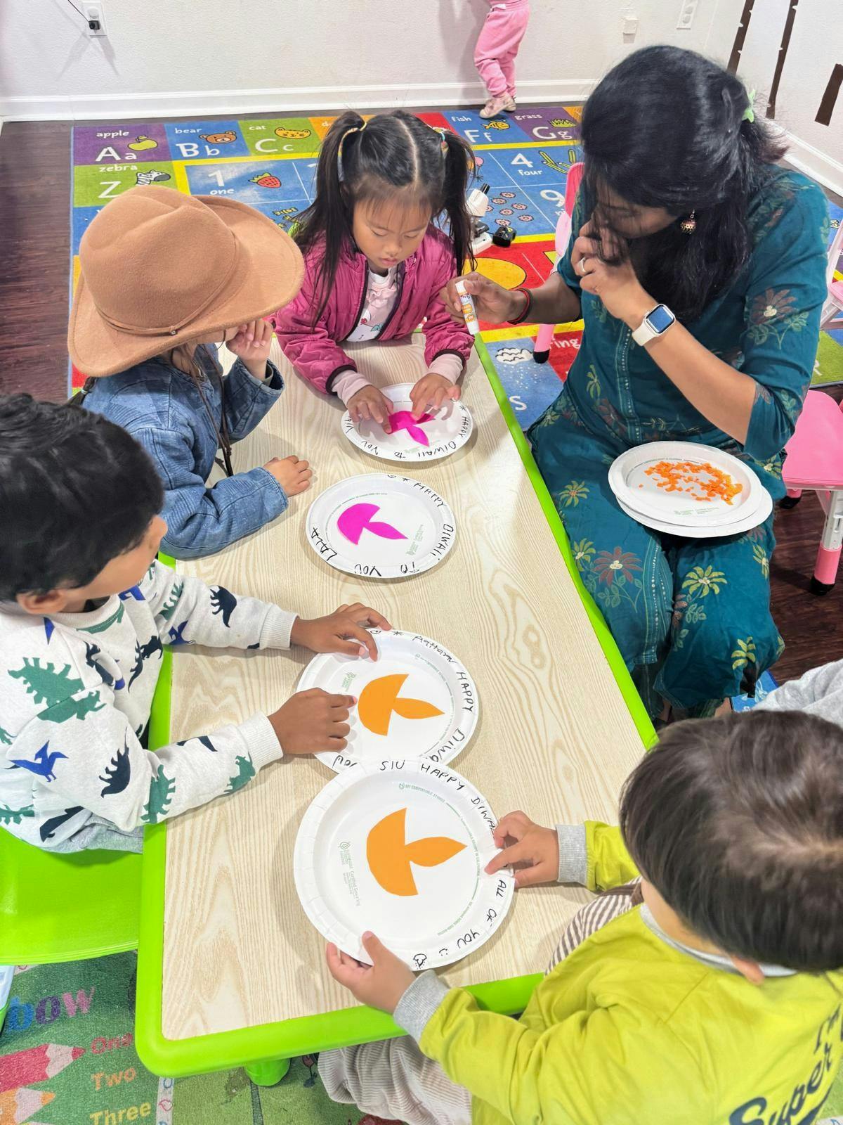 Adult and children at a table doing a craft with paper plates