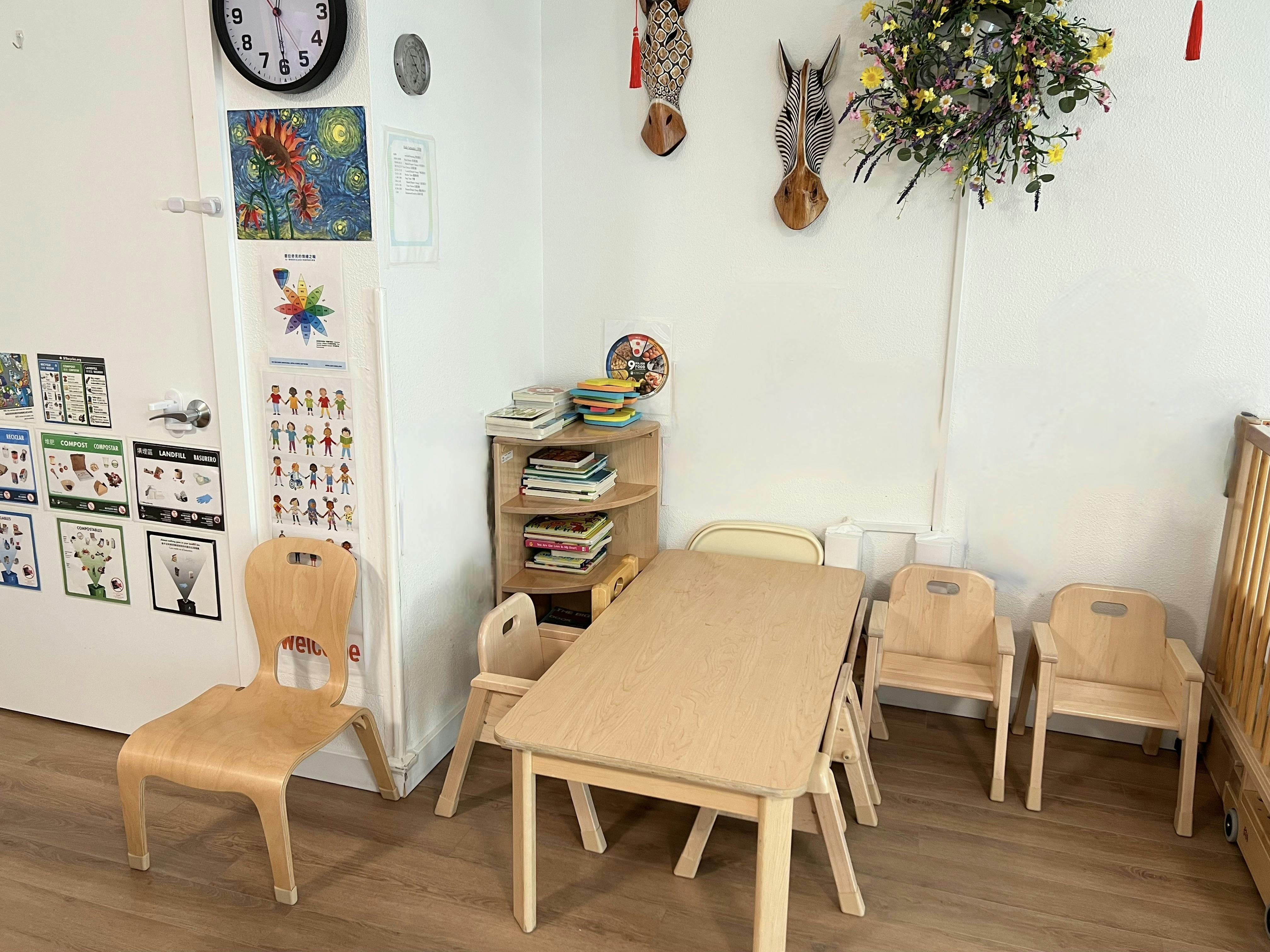 Small wooden table and chairs in a classroom with wall posters and decor