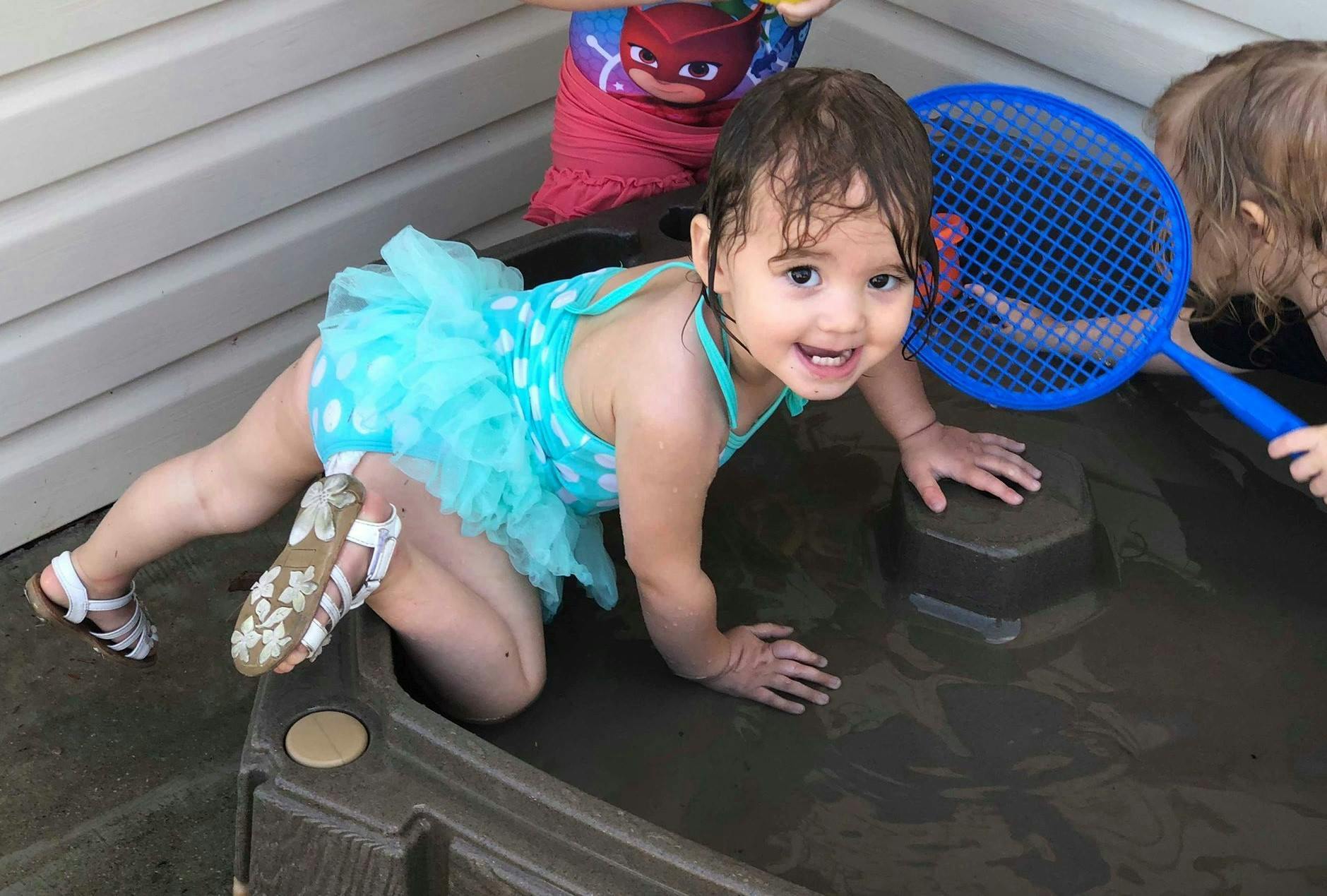 Child in a swimsuit playing in water