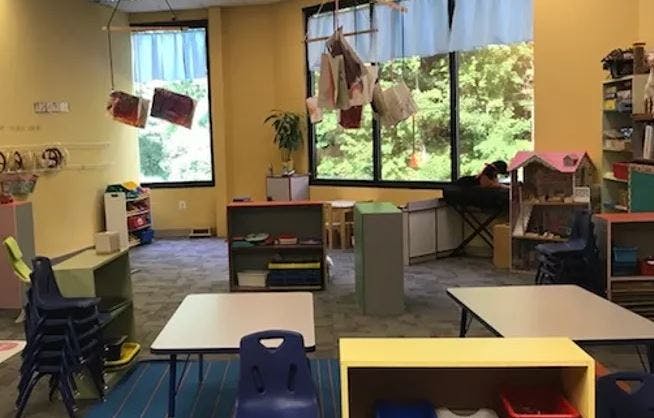 Classroom with tables, chairs, and shelves
