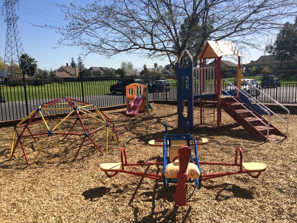 Playground with a climbing dome, slide, and airplane-shaped seesaw