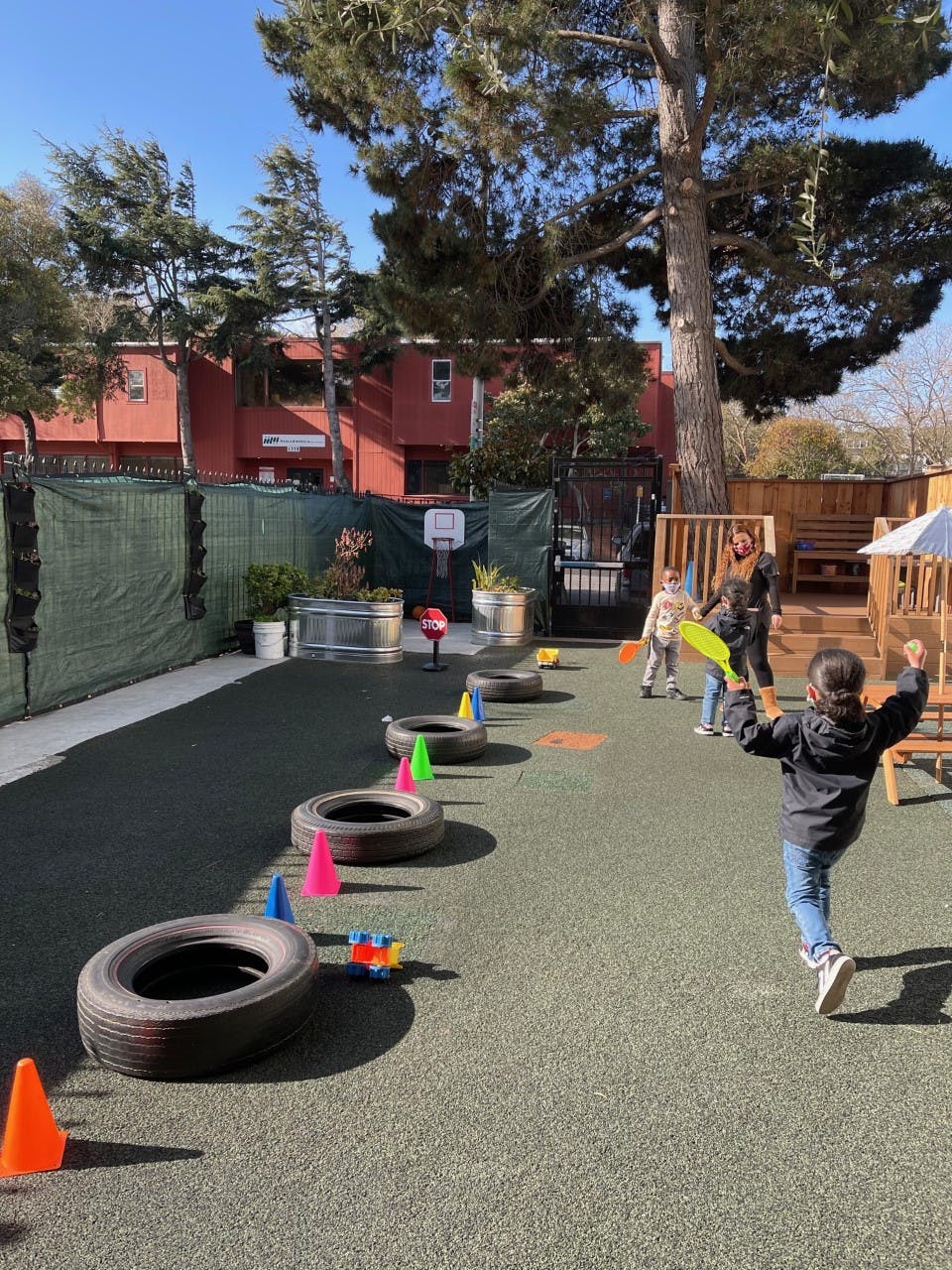 Children playing with tires and cones on a playground