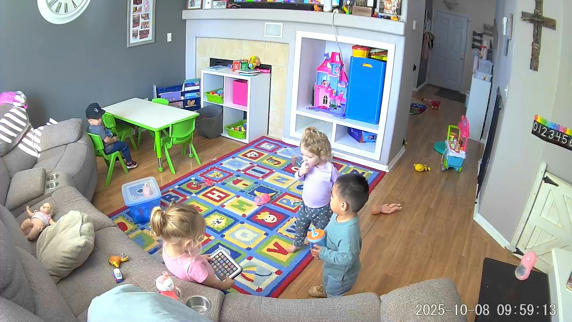 Three children playing in a living room with toys and a rug