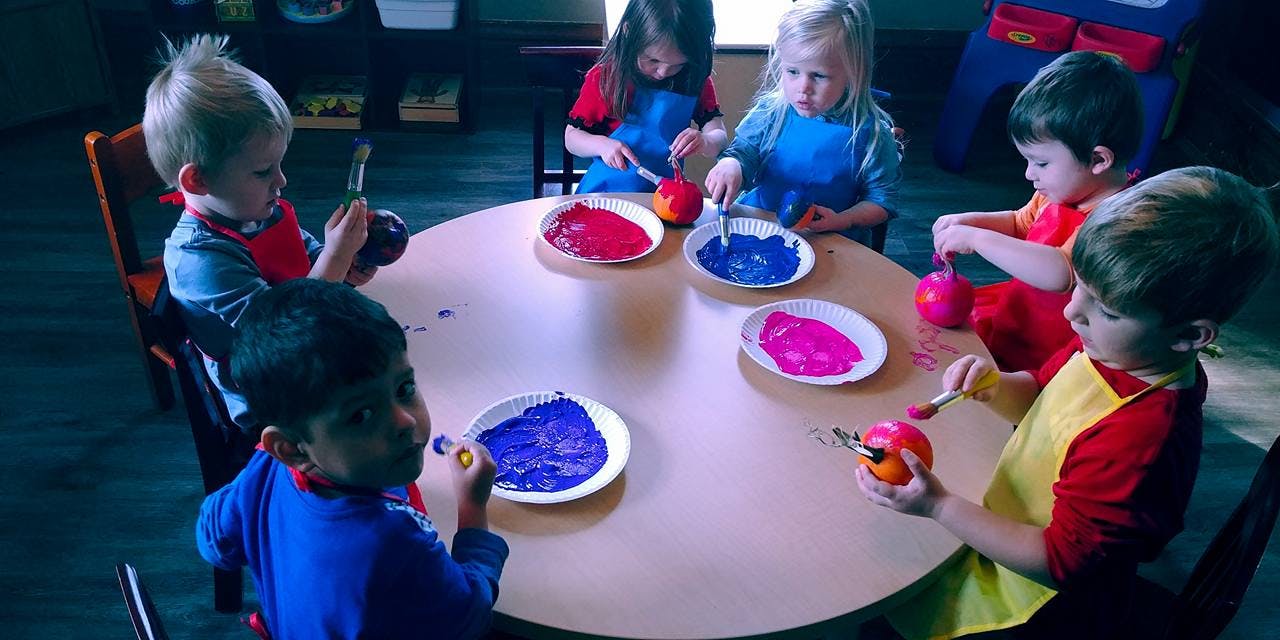 Children painting at a round table