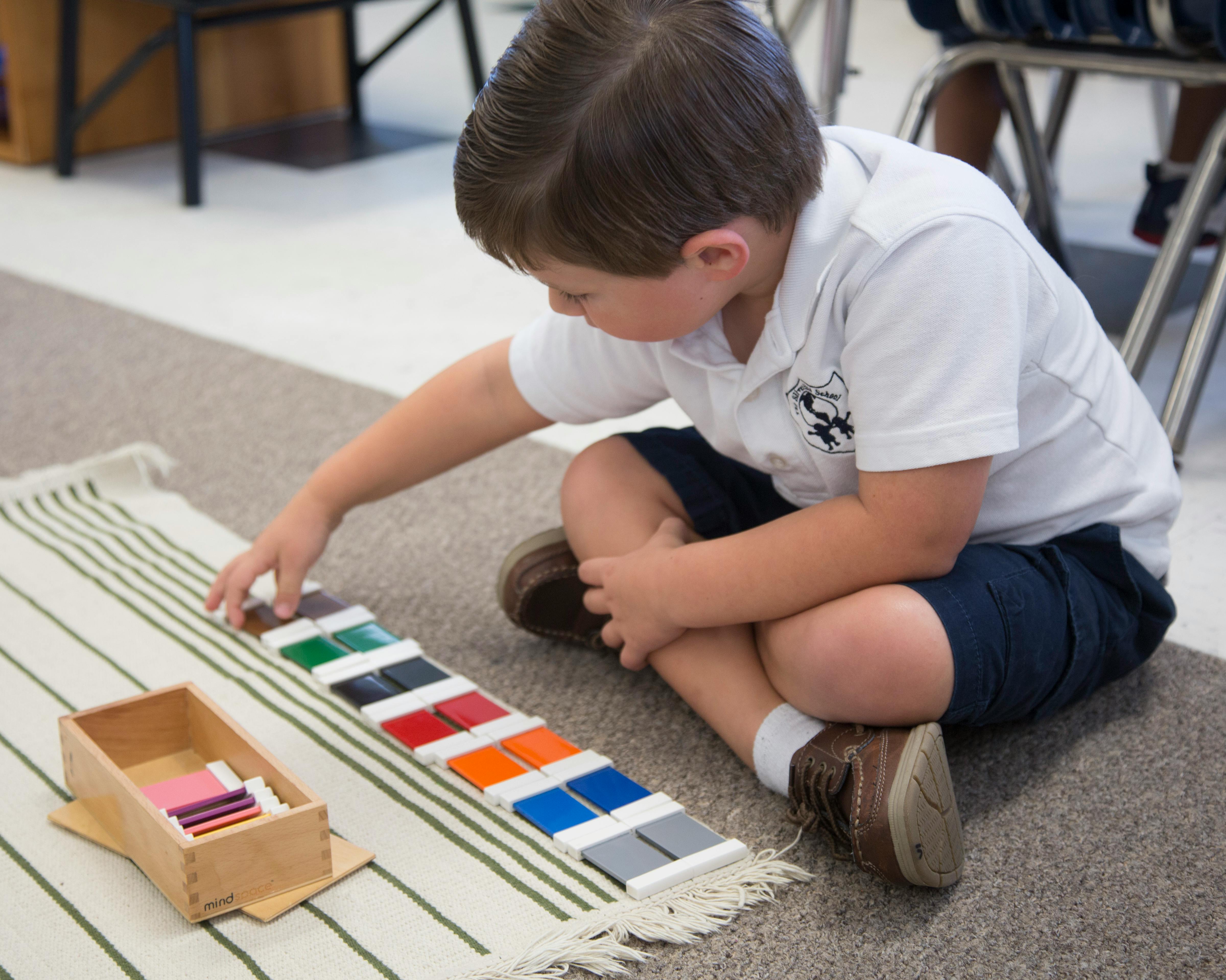 Child sitting on floor playing with colorful blocks