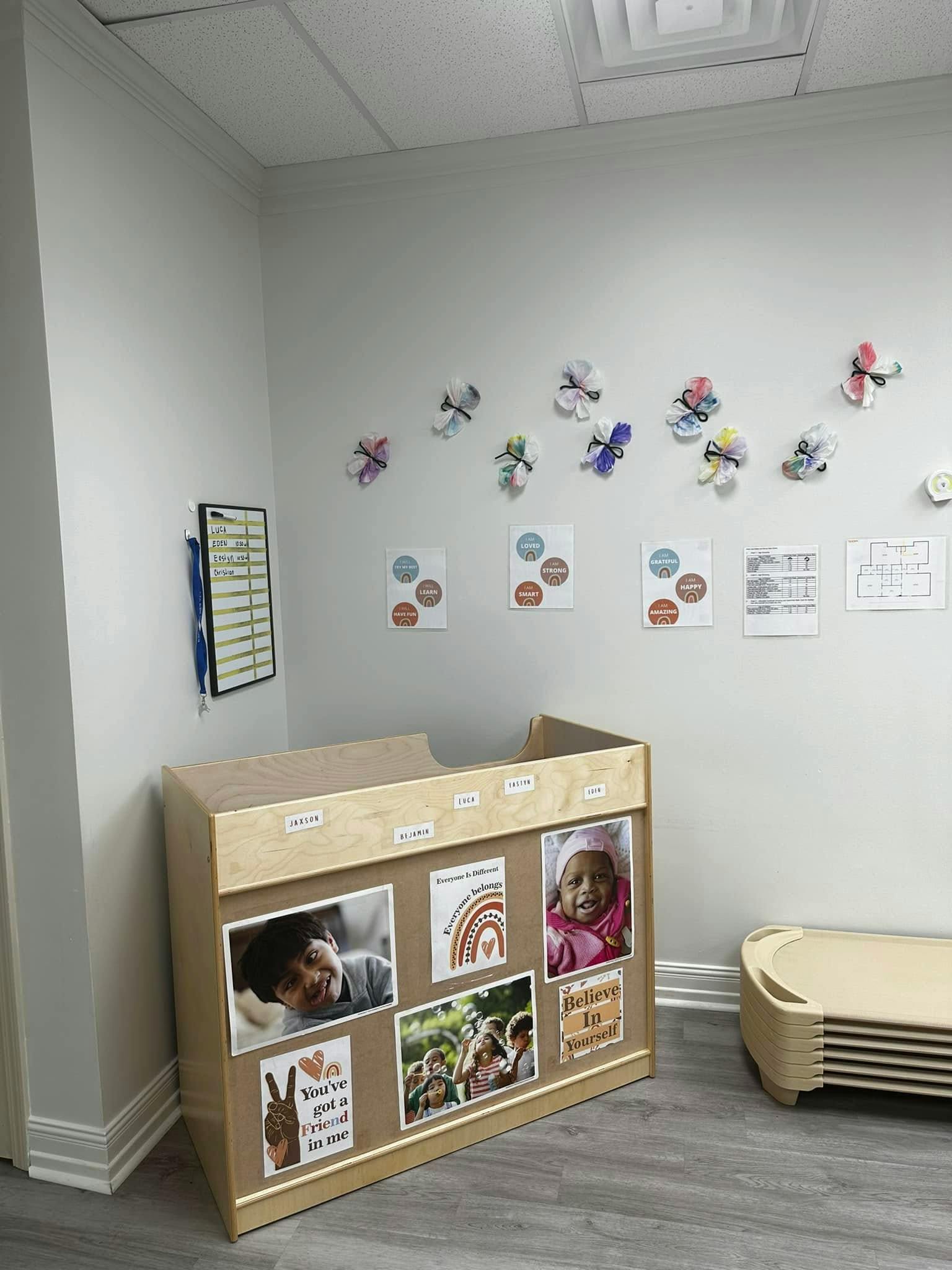 Classroom corner with wooden cubby unit featuring children's photos and decorative elements