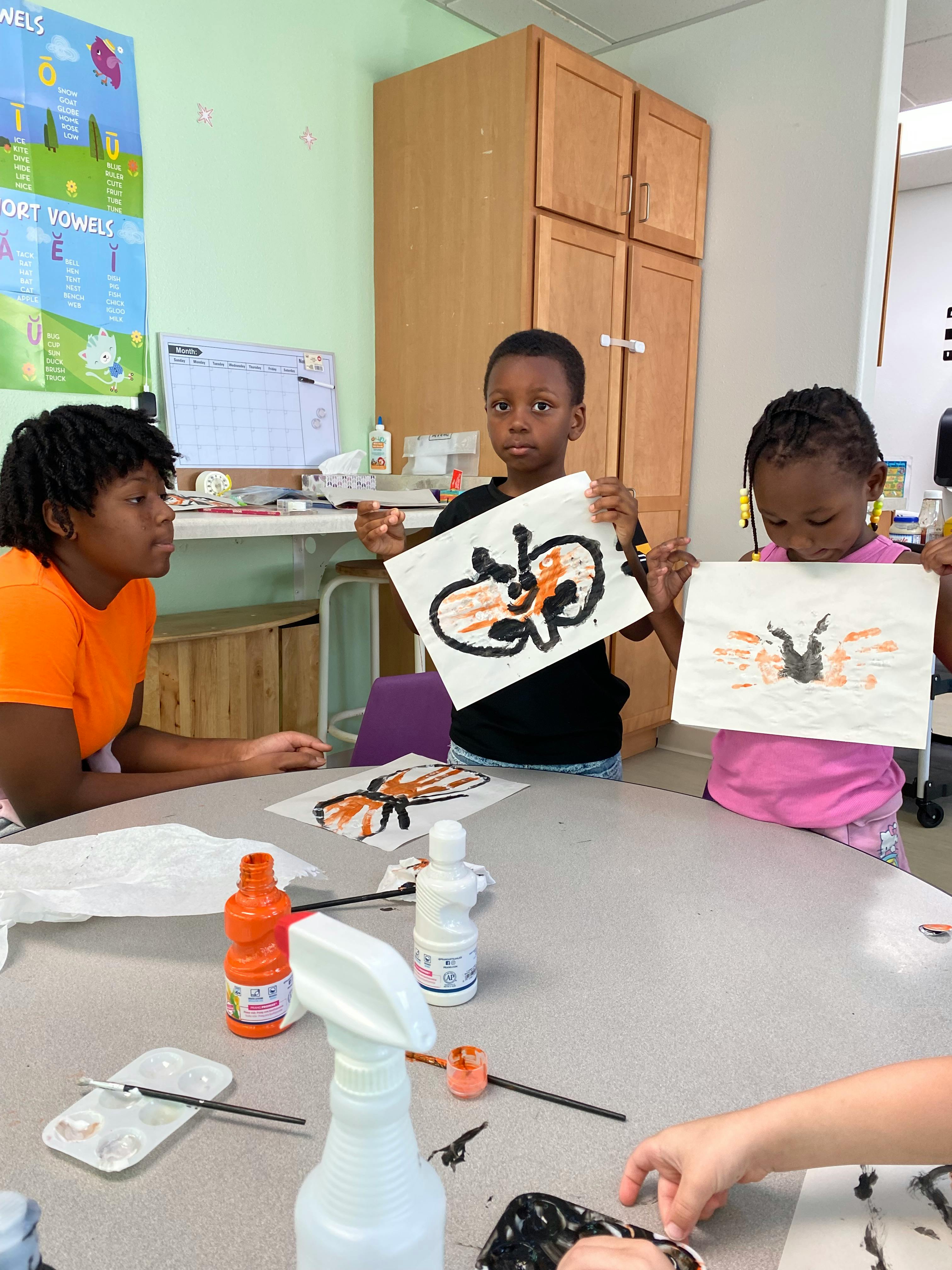 Children showing their handprint art in a classroom