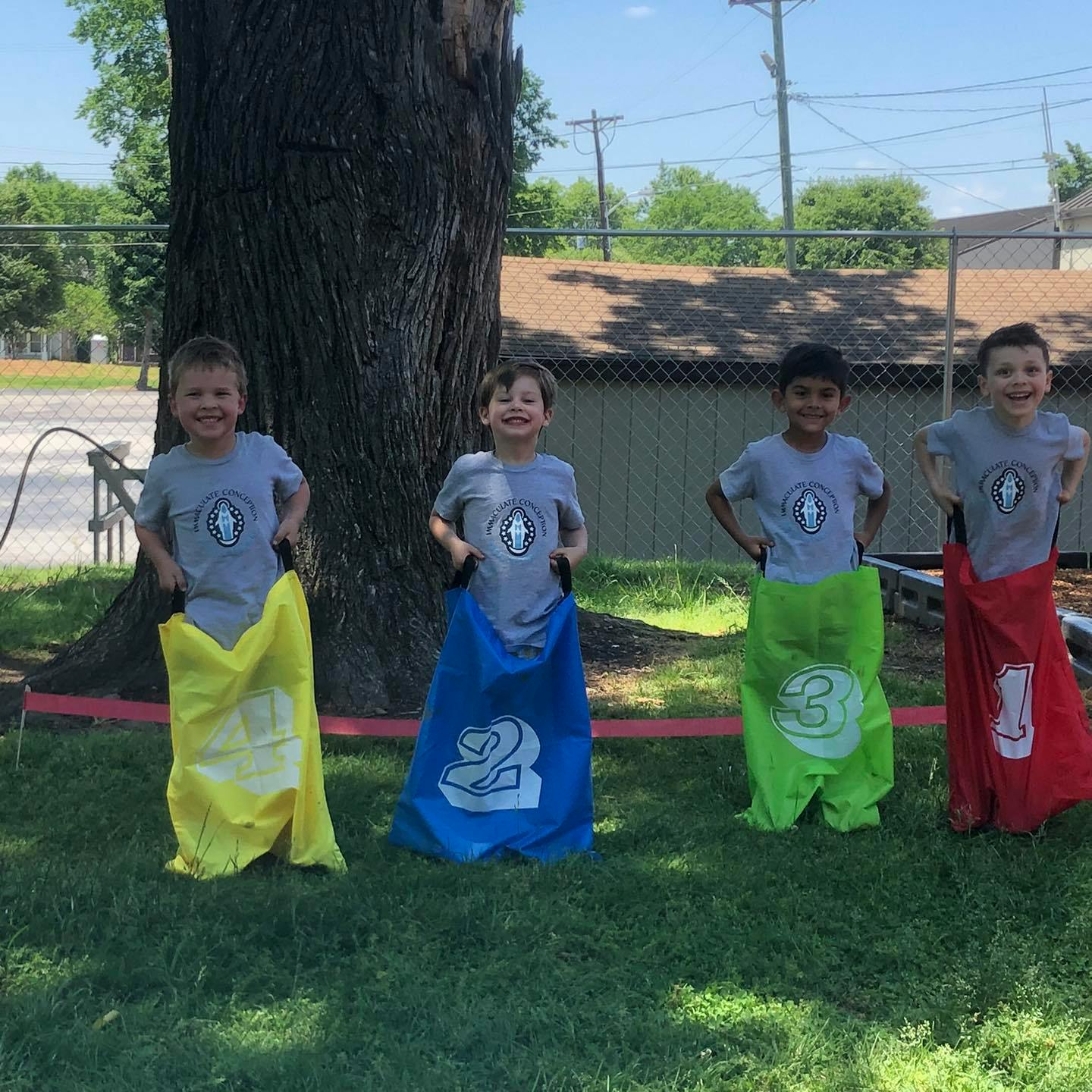 Four children in colorful sacks for a sack race