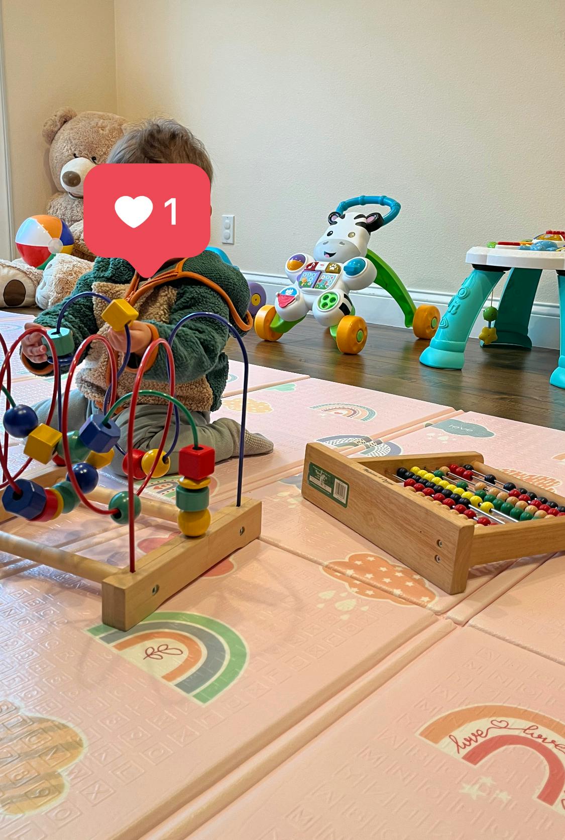Child playing with a bead maze toy on a playmat