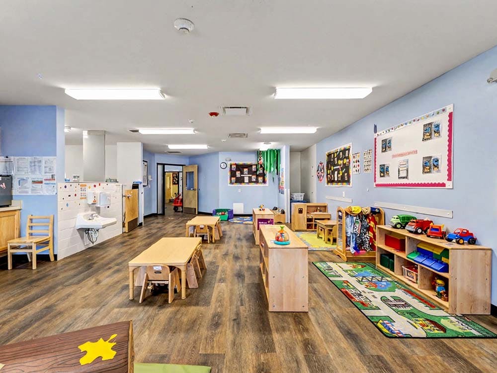 Empty colorful children's classroom with small tables and chairs