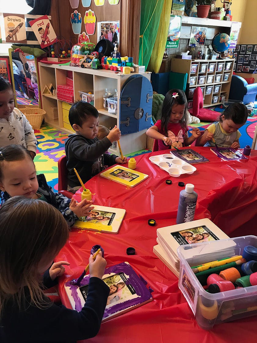Children painting picture frames in a classroom