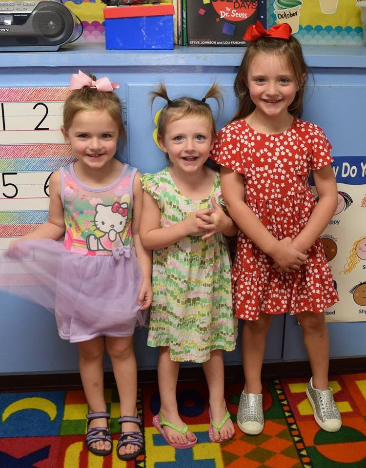 Three children standing together in a row