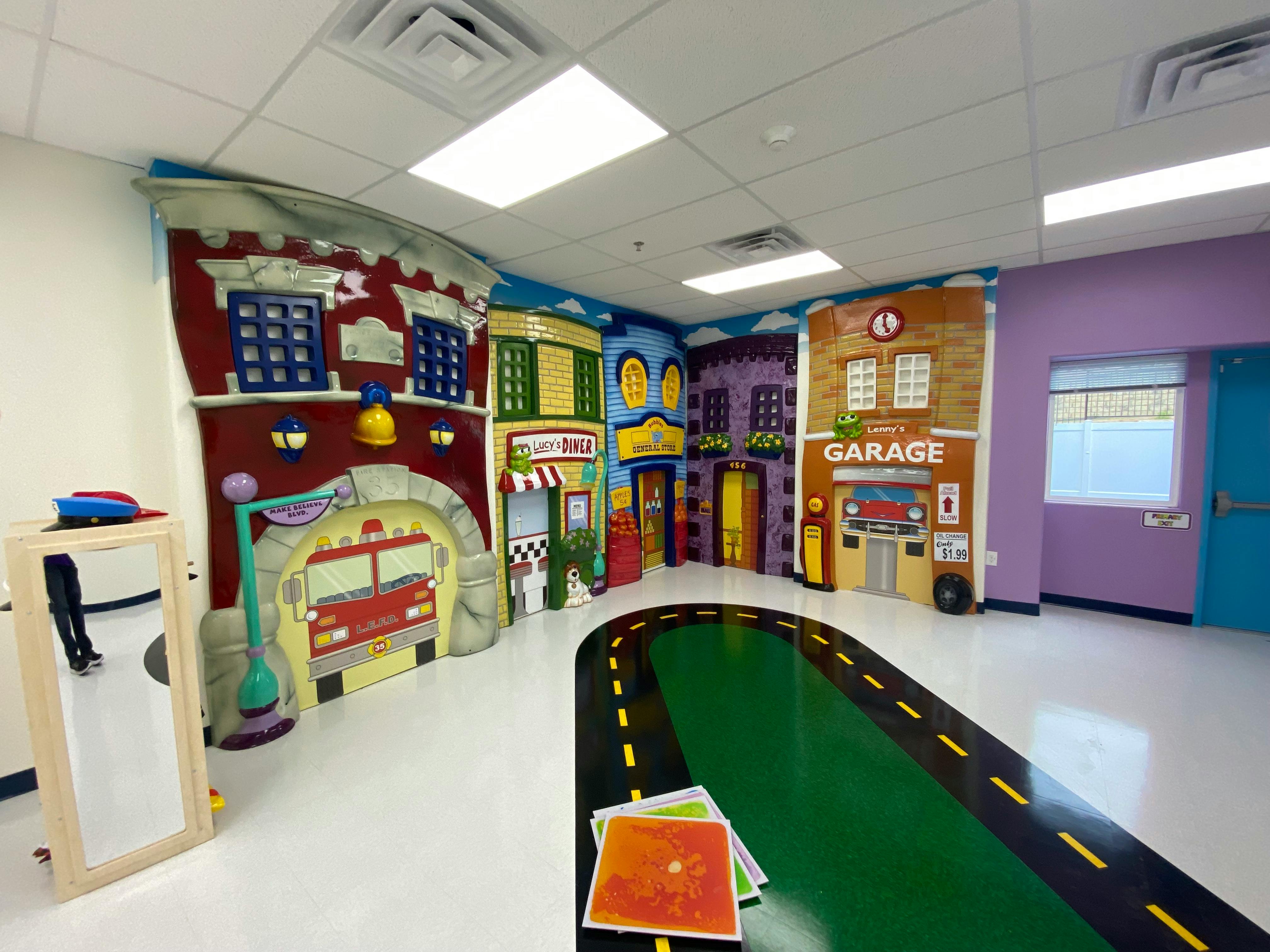 Playroom with city-themed wall murals and a road painted on the floor