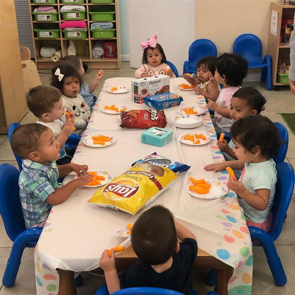 Children sitting at a table eating snacks