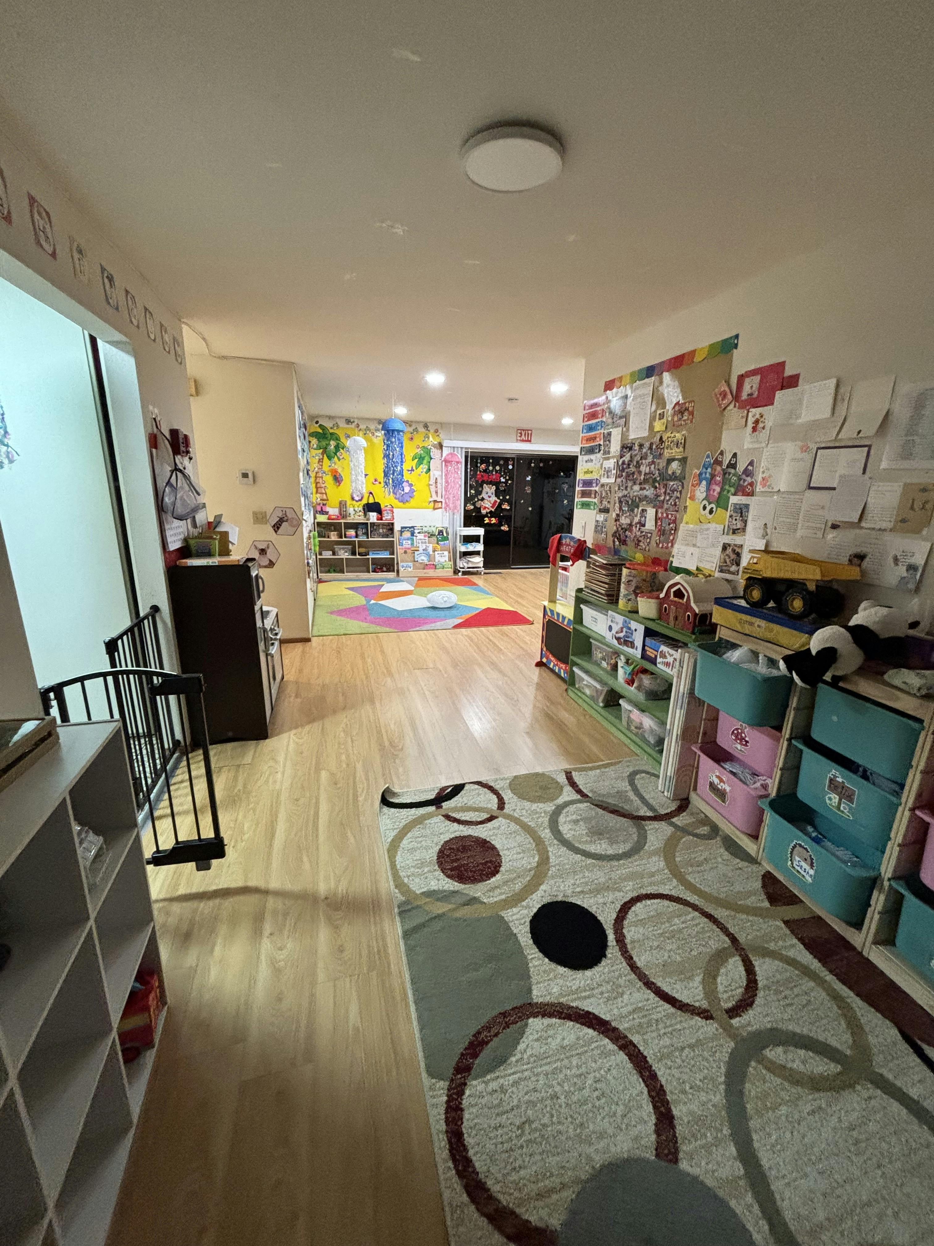 Hallway of a brightly decorated classroom with colorful rugs and walls covered in artwork