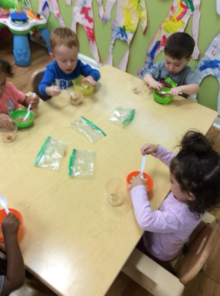 Children at a table with bowls and spoons