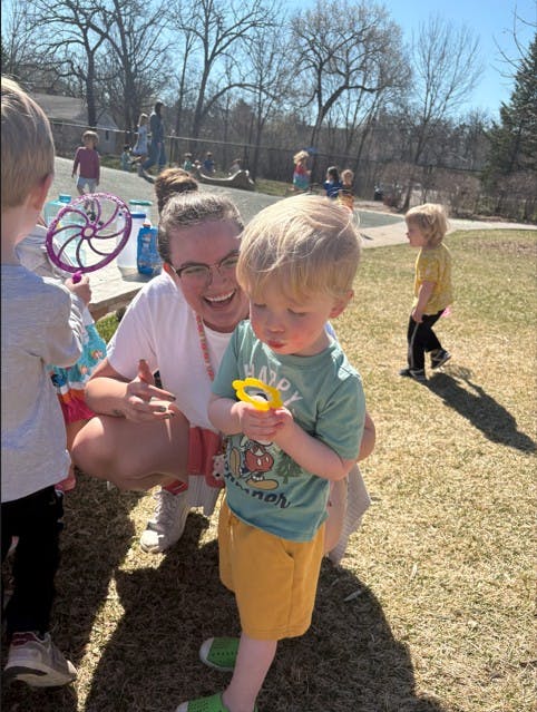 Adult and child looking at a magnifying glass outdoors