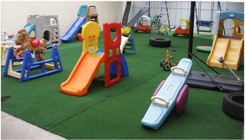 Indoor playground with slides, seesaw, and other play equipment