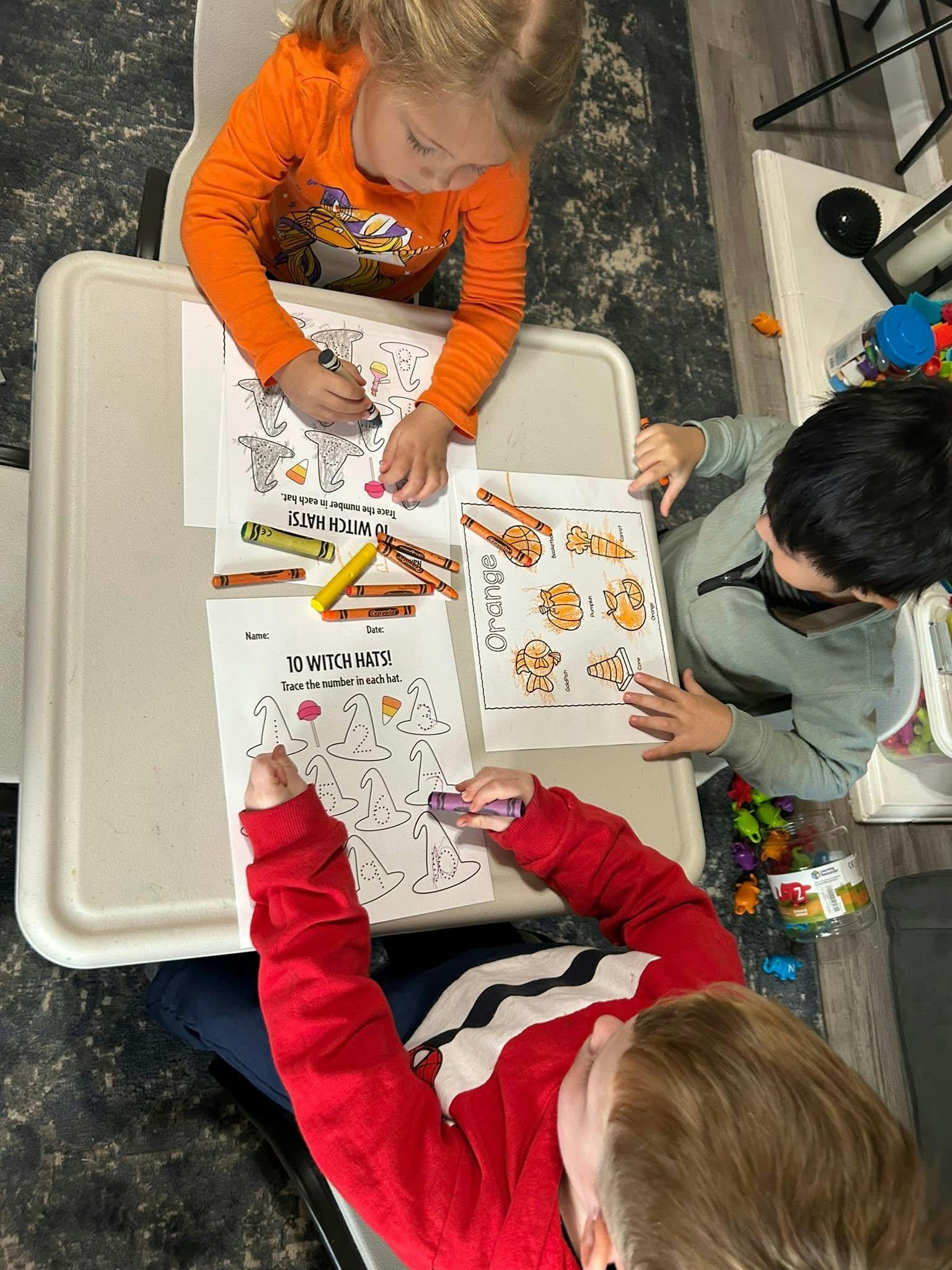 Three children coloring at a table