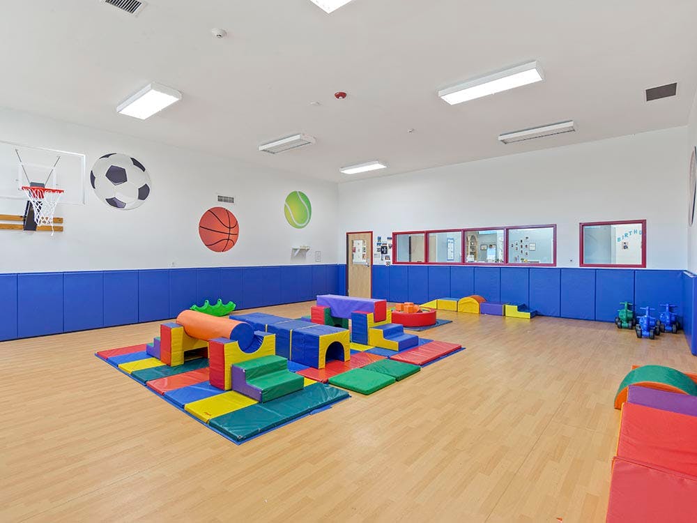 Colorful soft play equipment on a light wood floor in a playroom