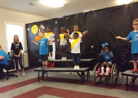 Children on risers performing, one child in a wheelchair