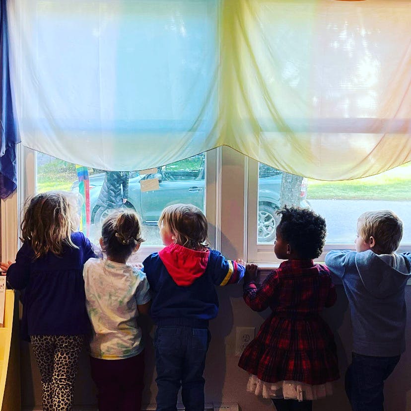 Five children looking out a window
