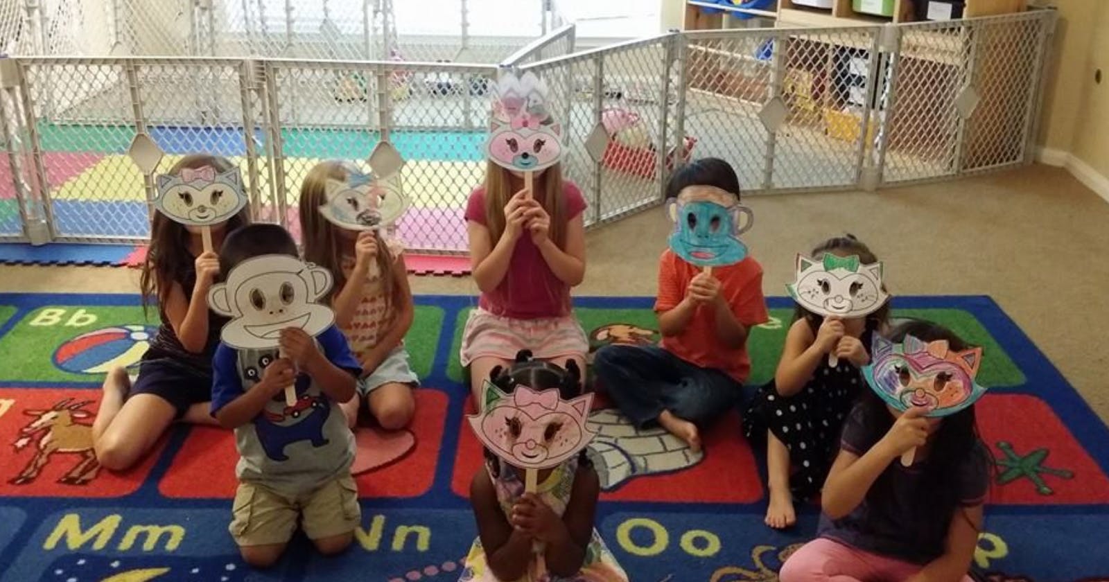 Children holding up animal masks in a classroom