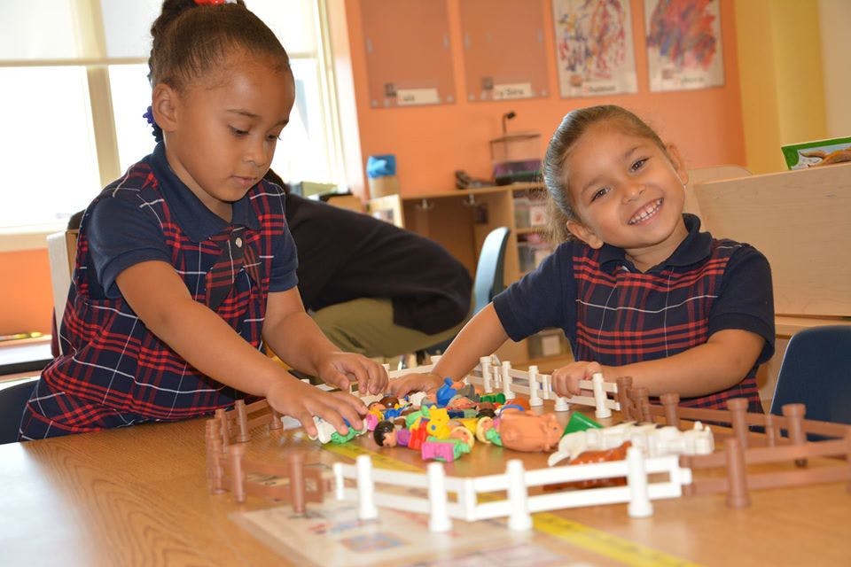 Two children playing with toys at a table