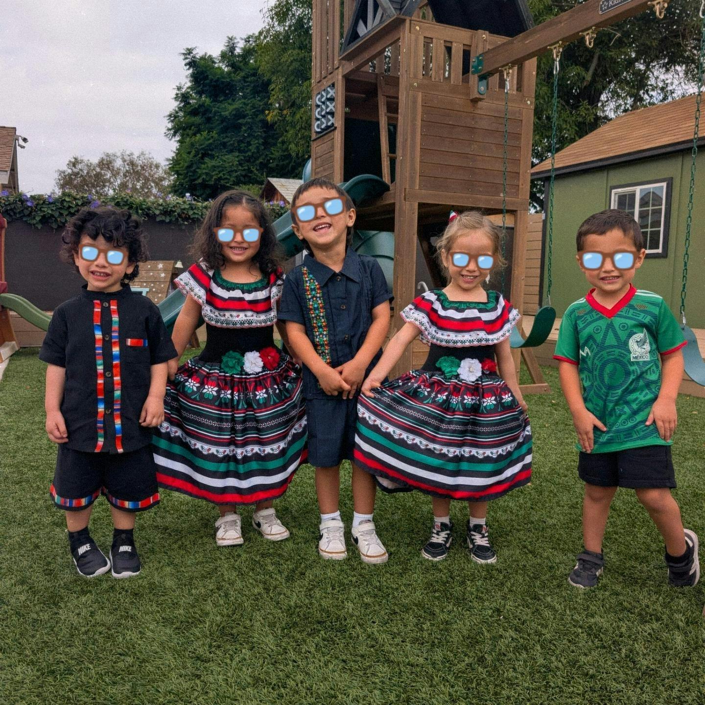Five children standing in a line at a playground