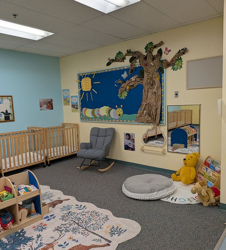 Cribs in a nursery room with a rocking chair and children's decorations