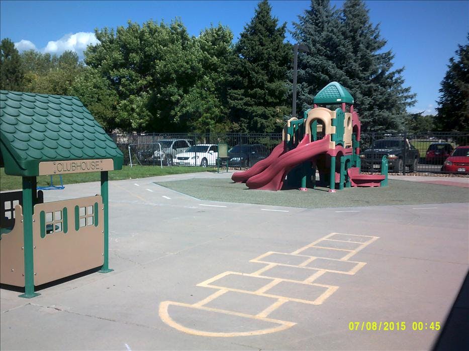 Playground with Clubhouse structure and a colorful slide set with hopscotch lines