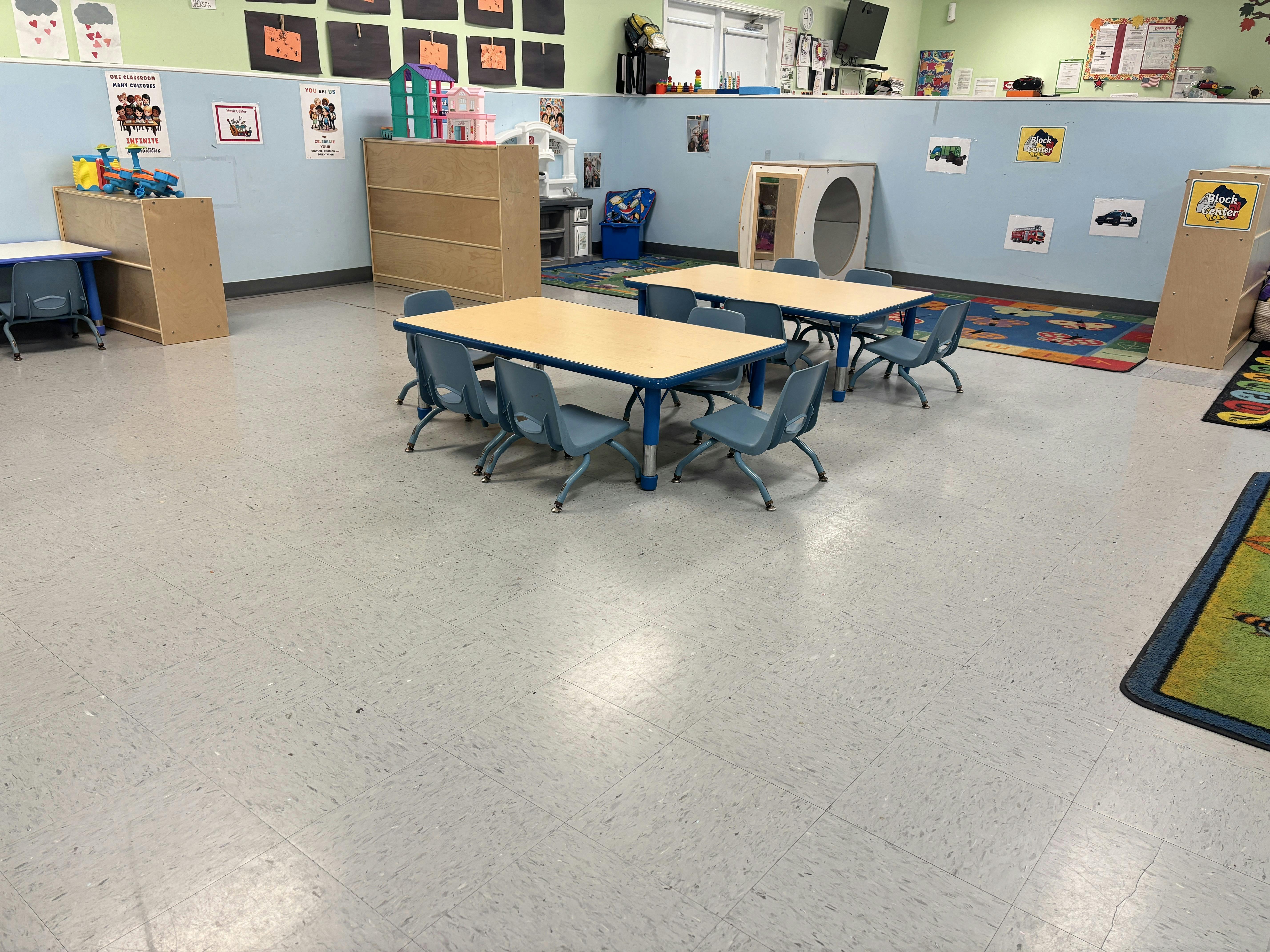 Empty tables and small chairs in a preschool classroom