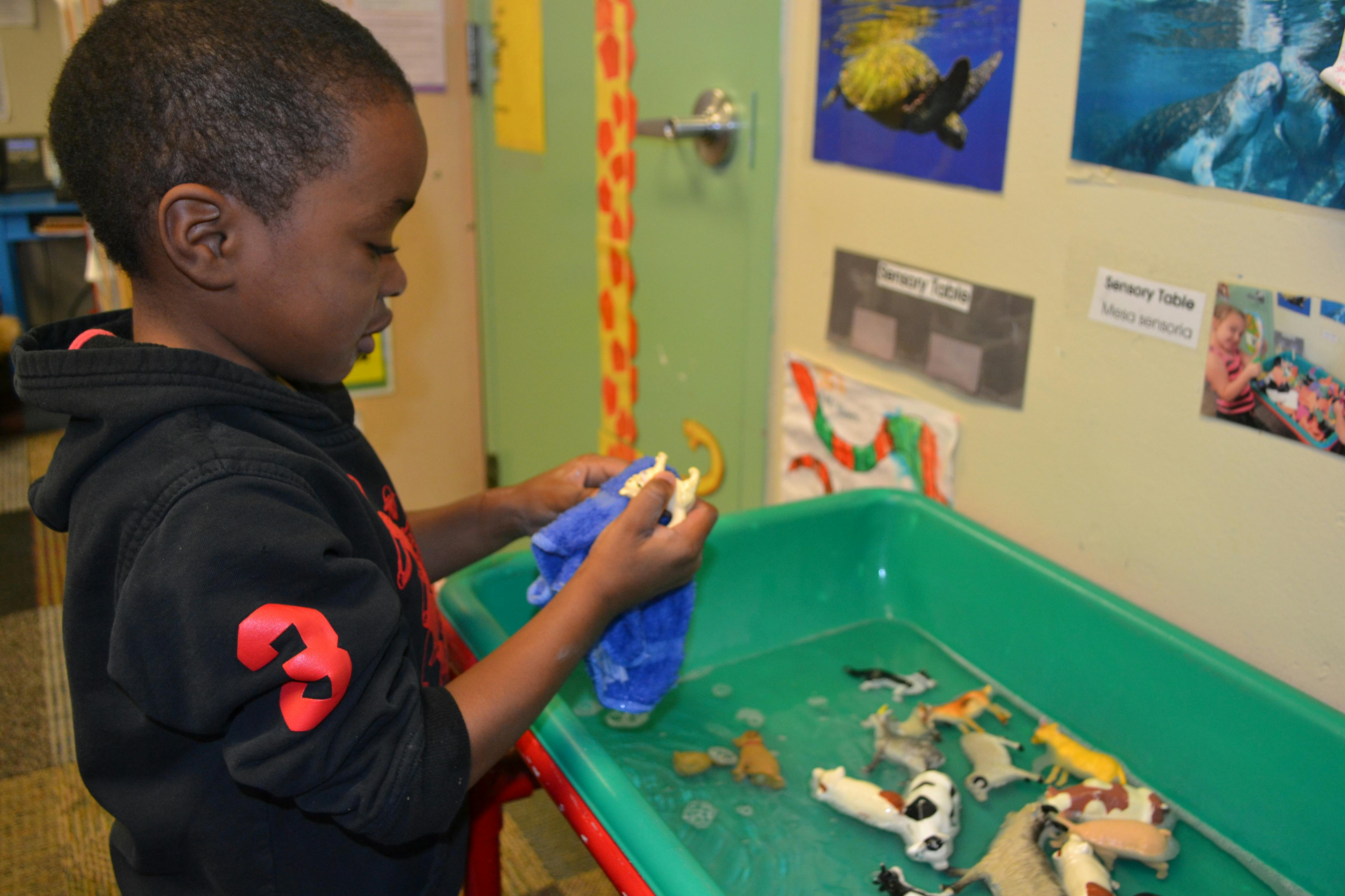 Child playing with toys in a green bin