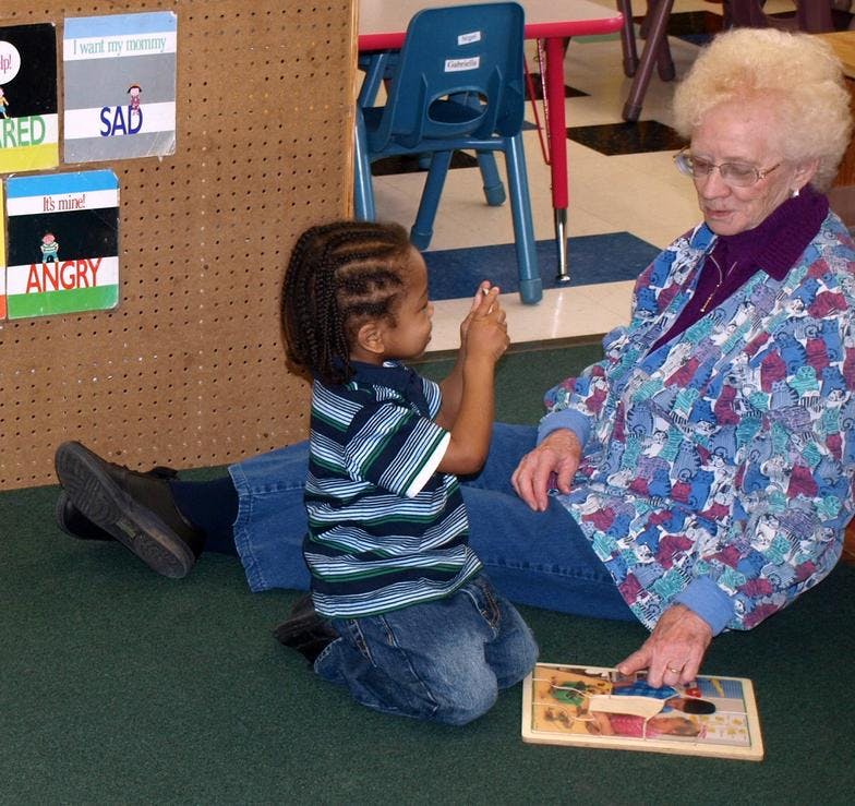 Adult and child playing with a puzzle on the floor