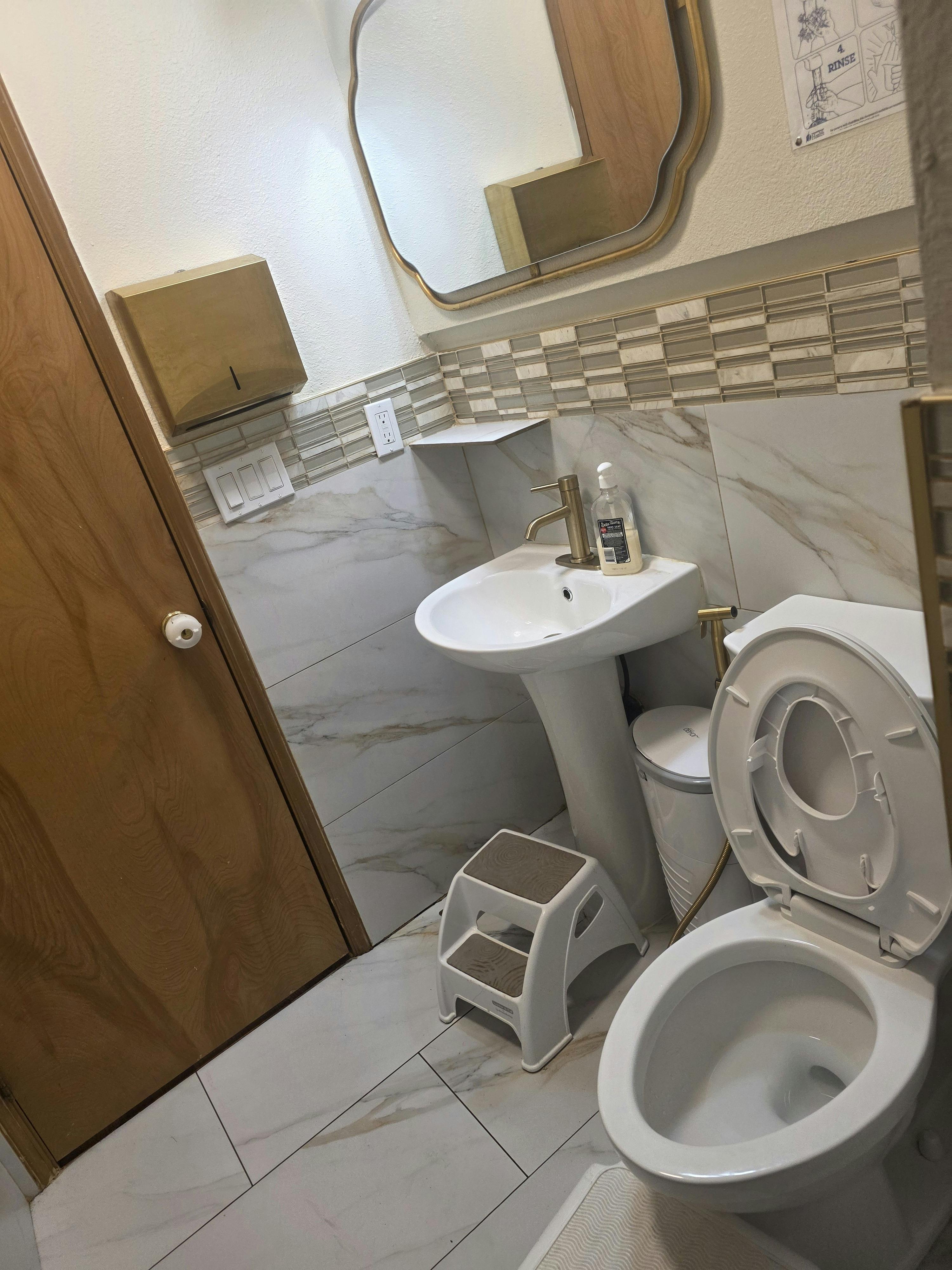 Small restroom with a pedestal sink and toilet