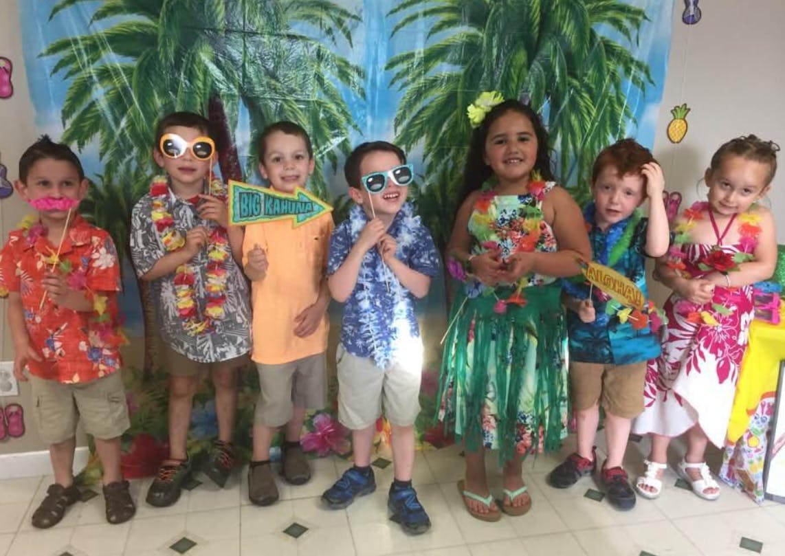 Group of children in Hawaiian-themed clothing and accessories