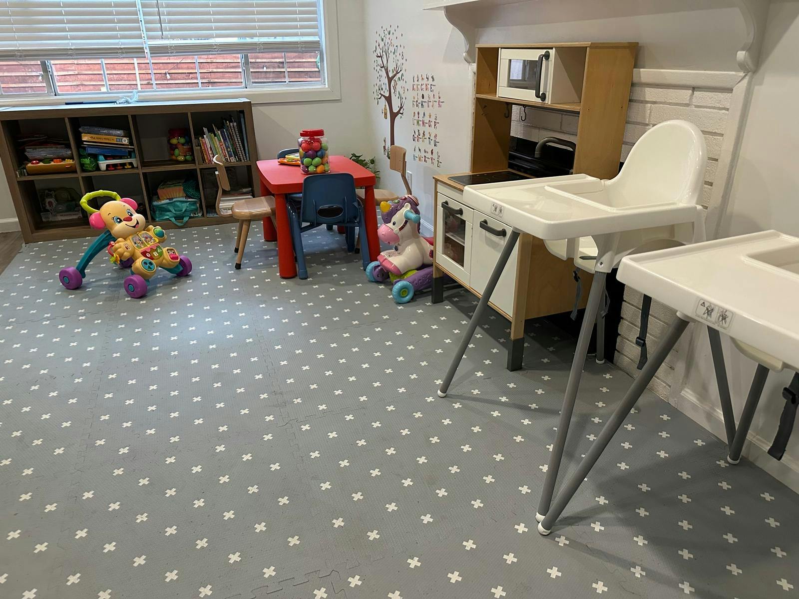 Playroom with toys, small table and chairs, and high chairs