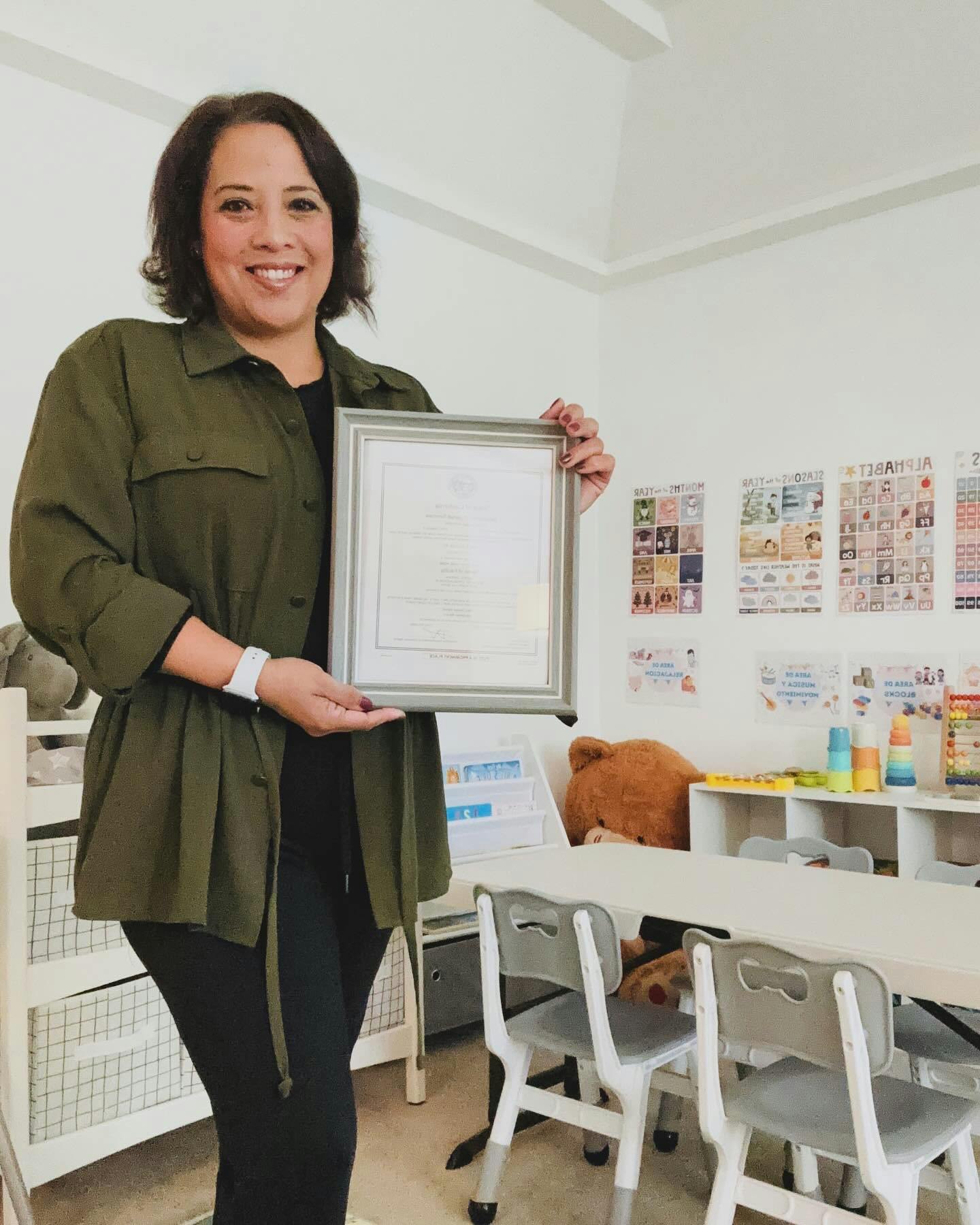 Person holding a framed certificate in a classroom